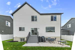 Back of property with stucco siding and a patio area