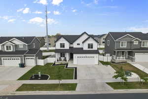View of front of house with a residential view, a porch, concrete driveway, an attached garage, and board and batten siding