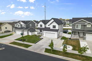 View of front facade featuring a residential view, a garage, driveway, and a porch