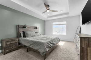 Bedroom featuring light carpet, a raised ceiling, a ceiling fan, baseboards, and recessed lighting