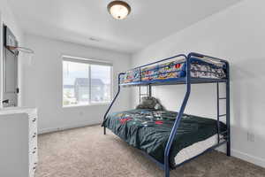 Bedroom featuring carpet and baseboards