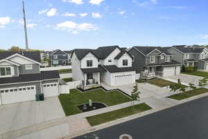 View of front of property with a residential view, driveway, a garage, board and batten siding, and a porch