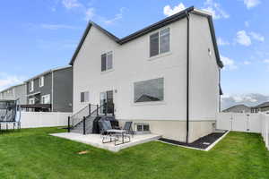 Back of property featuring a trampoline, a patio, a gate, and stucco siding