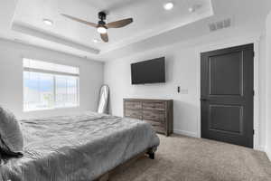 Bedroom with a tray ceiling, carpet floors, recessed lighting, baseboards, and ceiling fan