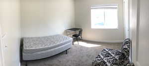 Bedroom featuring carpet floors and baseboards