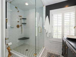 Full bath with a shower stall, vanity, and tile patterned floors
