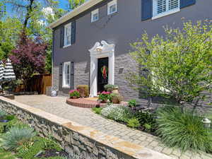 View of front of house featuring fence, stucco siding, and stone siding