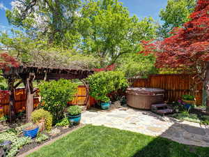 View of yard featuring a hot tub and a patio
