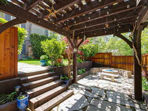 View of patio with a fire pit, a fenced backyard, a ceiling fan, and a pergola