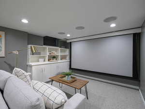 Carpeted home theater with recessed lighting and baseboards