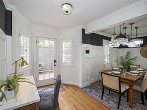 Dining space featuring light wood-type flooring, a chandelier, ornamental molding, and baseboards