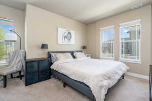Bedroom with light colored carpet and baseboards
