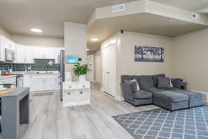 Living room with new LVP flooring, baseboards, and recessed lighting