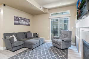 Living room featuring new LVP flooring, baseboards, and a fireplace