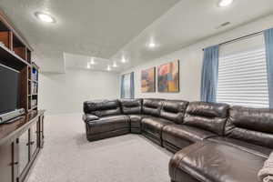 Carpeted living area featuring recessed lighting and baseboards