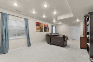 Living room featuring light carpet, baseboards, and recessed lighting