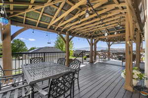 Wooden deck featuring a gazebo and outdoor dining area