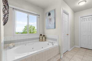 Bathroom featuring a whirlpool tub, tile patterned floors, and baseboards