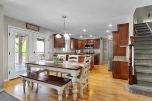 Dining space with stairs, light wood-style floors, recessed lighting, and baseboards