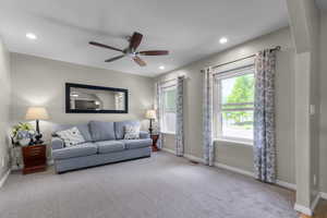 Carpeted living area with baseboards, a ceiling fan, and recessed lighting