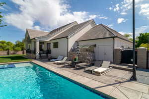 Back of house featuring a patio, a tiled roof, a gate, and stucco siding