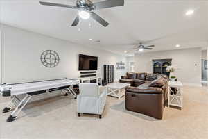 Living area featuring light colored carpet, a ceiling fan, recessed lighting, and baseboards