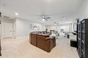 Living area with light colored carpet, recessed lighting, a ceiling fan, and baseboards