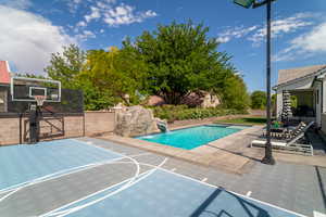 View of basketball court featuring basketball hoop and fence