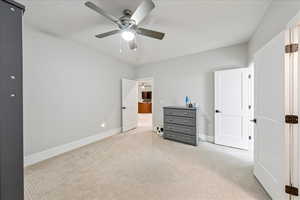 Bedroom with light carpet, baseboards, and ceiling fan
