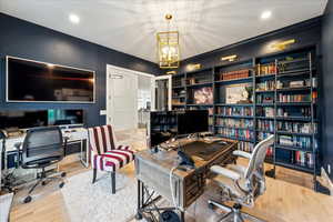 Office space with wood finished floors and a chandelier