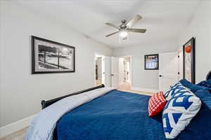 Bedroom with baseboards, light colored carpet, and ceiling fan