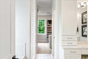 Bathroom featuring vanity, baseboards, marble look tiles, and a shower