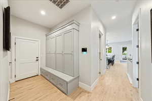 Mudroom featuring light wood finished floors, recessed lighting, and baseboards