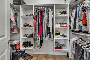 Walk in closet with wood finished floors