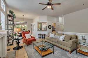 Living room with hardwood / wood-style flooring, a ceiling fan, and a chandelier