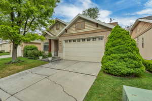 Ranch-style house with stone siding, concrete driveway, a garage, a front yard, and stucco siding