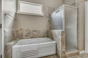 Bathroom with a stall shower and a bath