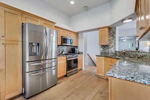 Kitchen featuring stainless steel appliances, a sink, light brown cabinetry, tasteful backsplash, and recessed lighting