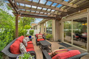 View of patio / terrace featuring an outdoor living space, a deck, fence, and a pergola