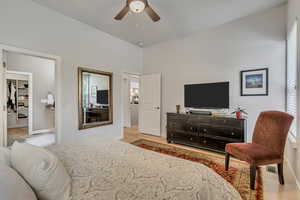 Bedroom with light wood finished floors, a walk in closet, baseboards, and a closet