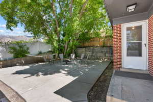 View of patio with a fenced backyard, a mountain view, and an outdoor fire pit