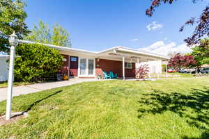Single story home with brick siding and a front yard