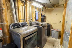 Washroom with separate washer and dryer and brick patterned flooring