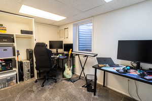 Home office with a drop ceiling and carpet