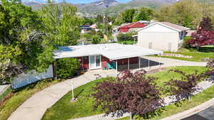 View of front of property with brick siding, a mountain view, and a front yard
