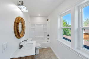 Bathroom featuring toilet, vanity, shower / tub combination, baseboards, and recessed lighting