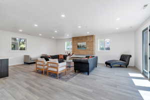 Living area with recessed lighting, baseboards, and light wood-type flooring