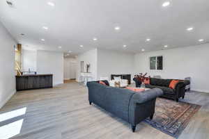 Living room with recessed lighting, light wood-type flooring, and baseboards