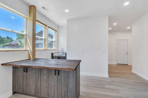Office with recessed lighting, baseboards, light wood-type flooring, and a sink