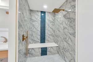 Full bath featuring a marble finish shower, vanity, and recessed lighting